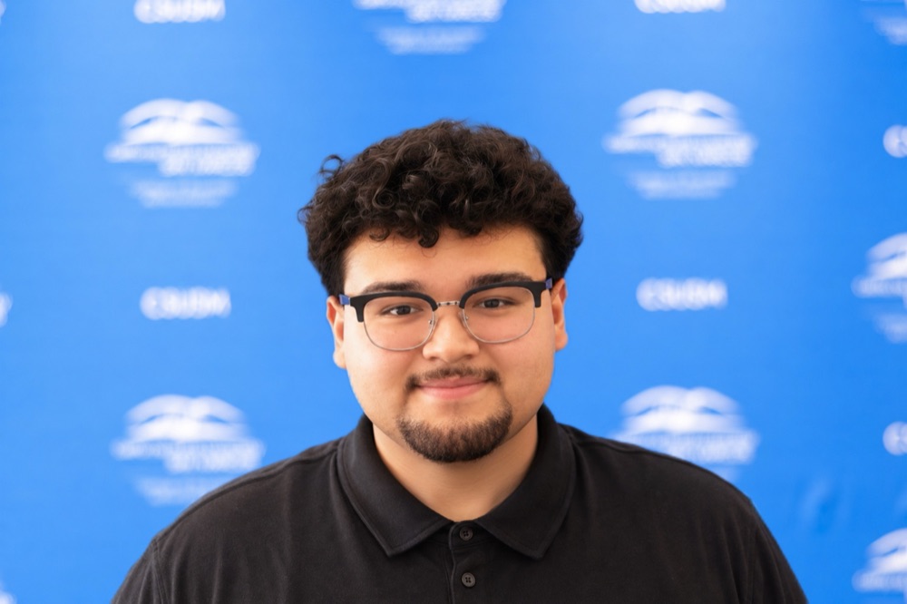 Headshot of Eddie Loa smiling in a black polo